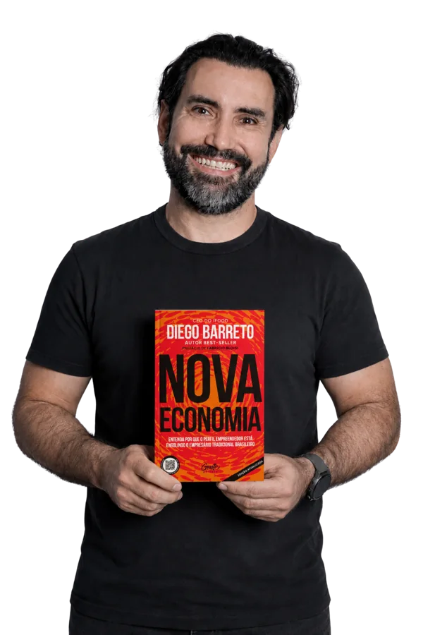 Diego Barreto segurando o livro A Nova Economia, Edição Atualizada